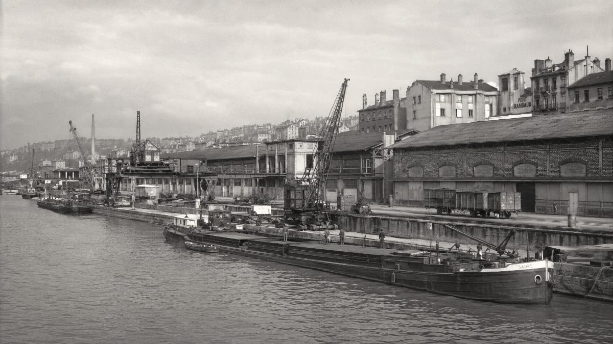 Port Rambaud à Lyon en activité avec des péniches, des entrepôts et des voies ferrées